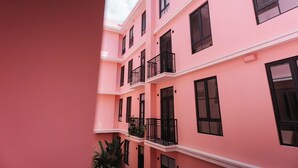 A pink multi-story building with balconies and windows. - The Glow Stay | Elegant and Modern | @SantaAna (Panama City)