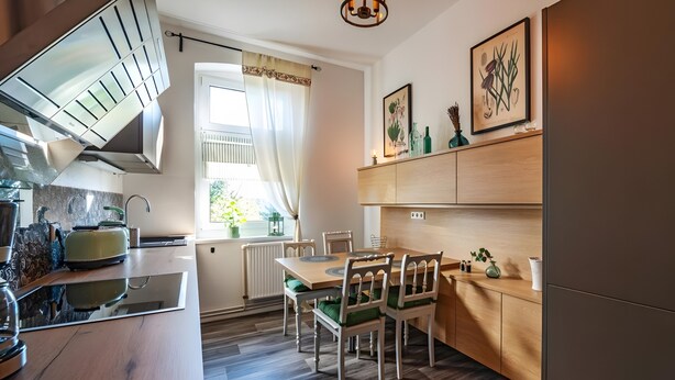 Una cucina moderna con zona pranzo, mobili in legno e una finestra con tende.
