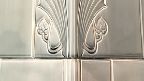 Un dettaglio a filo metallico con motivi floreali decorativi su una parete.
