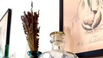 Een heldere glazen fles met een smalle hals en een breder voetje, geplaatst op een houten ondergrond.