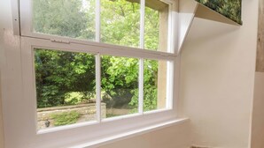 A room corner with a white window, a stone wall, and a small wooden ledge. - The Gardener's Cottage, Low Hall (Scarborough)