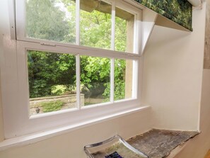 A room corner with a white window, a stone wall, and a small wooden ledge. - The Gardener's Cottage, Low Hall (Scarborough)