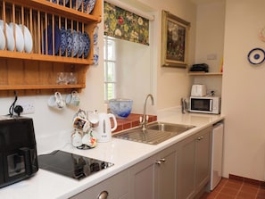 A kitchen with a microwave, toaster, kettle, and a sink. - The Gardener's Cottage, Low Hall (Scarborough)