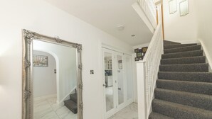A staircase with a handrail, a large ornate mirror, and a door with a glass panel. - Modern House with AC 4 Parking & Transport Links - Pass the Keys (Reading)