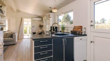 A kitchen with a black countertop, white cabinets, and a window.