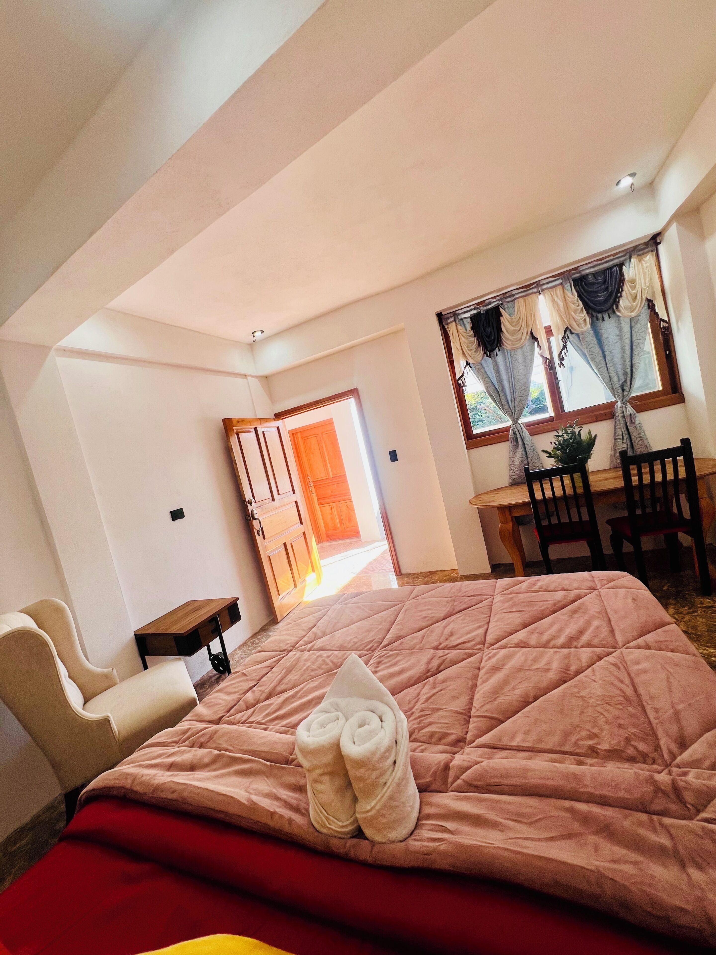 A bedroom with a bed, a desk, and a chair.