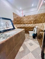 Un baño con lavamanos de mármol, bañera y retrete.