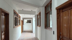 A hallway with patterned flooring, wooden doors, and white walls.
