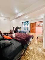 Un dormitorio con dos camas, un armario de madera, una mesita pequeña y una silla.