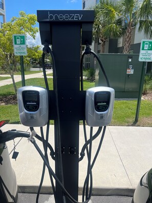 Une borne de recharge BreezEV dotée de deux prises de recharge, d’un panneau indiquant l’interdiction de se garer et d’un panneau d’avertissement concernant l’absence de PCB.