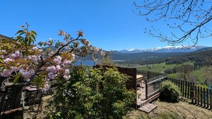 A wooden deck with a view of a mountainous landscape. - La Grange de la Petite Ourse with Large Furnished Terrace, Stunning Lake and Mountain Views (Les Angles)
