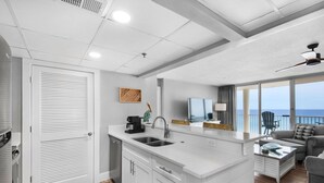 Een moderne keuken met een groot schiereiland, een eethoek met uitzicht, en een balkon met uitzicht.