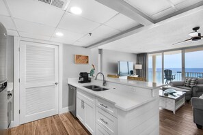Une cuisine moderne dotée d’un grand îlot central, d’un coin repas offrant une vue agréable et d’un balcon avec vue.