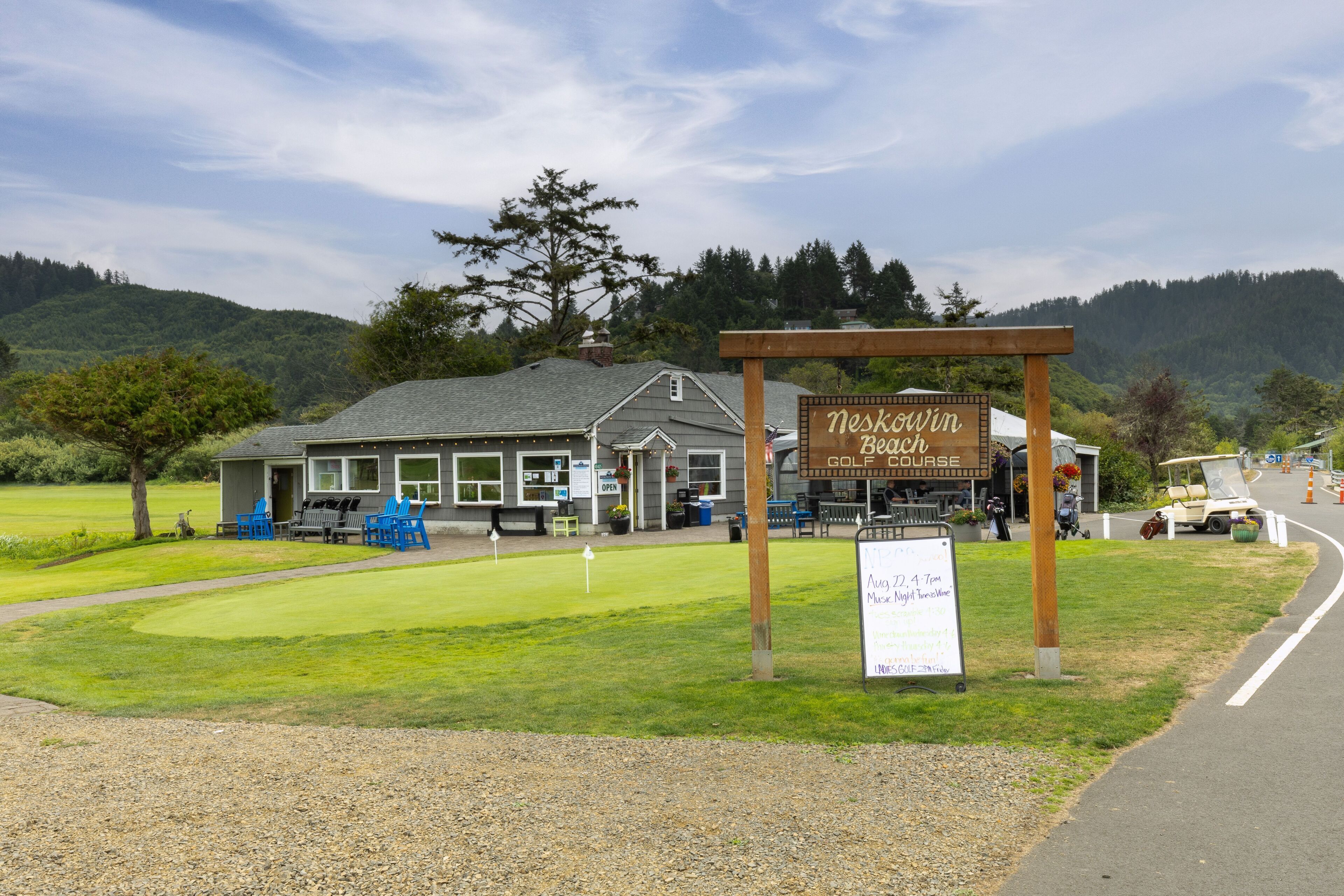 A golf course with a building labeled 'Neskowin Beach Golf Course' and a signboard with event details.
