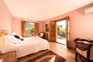 A bedroom with a bed, a chair, a desk, a window, and a door leading to a balcony. - All About Rif View Villa (Málaga)
