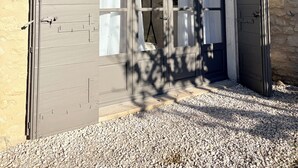 A building with a curved entrance, a tiled roof, and a gravel driveway. - Charming, quiet house - heated pool-5 minutes from pretty village of Eygalières (Orgon)