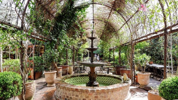 A garden with a central fountain, potted plants, and outdoor seating areas. - The Little Erko A Gateway to Sydneys Indie Heart (Newtown)