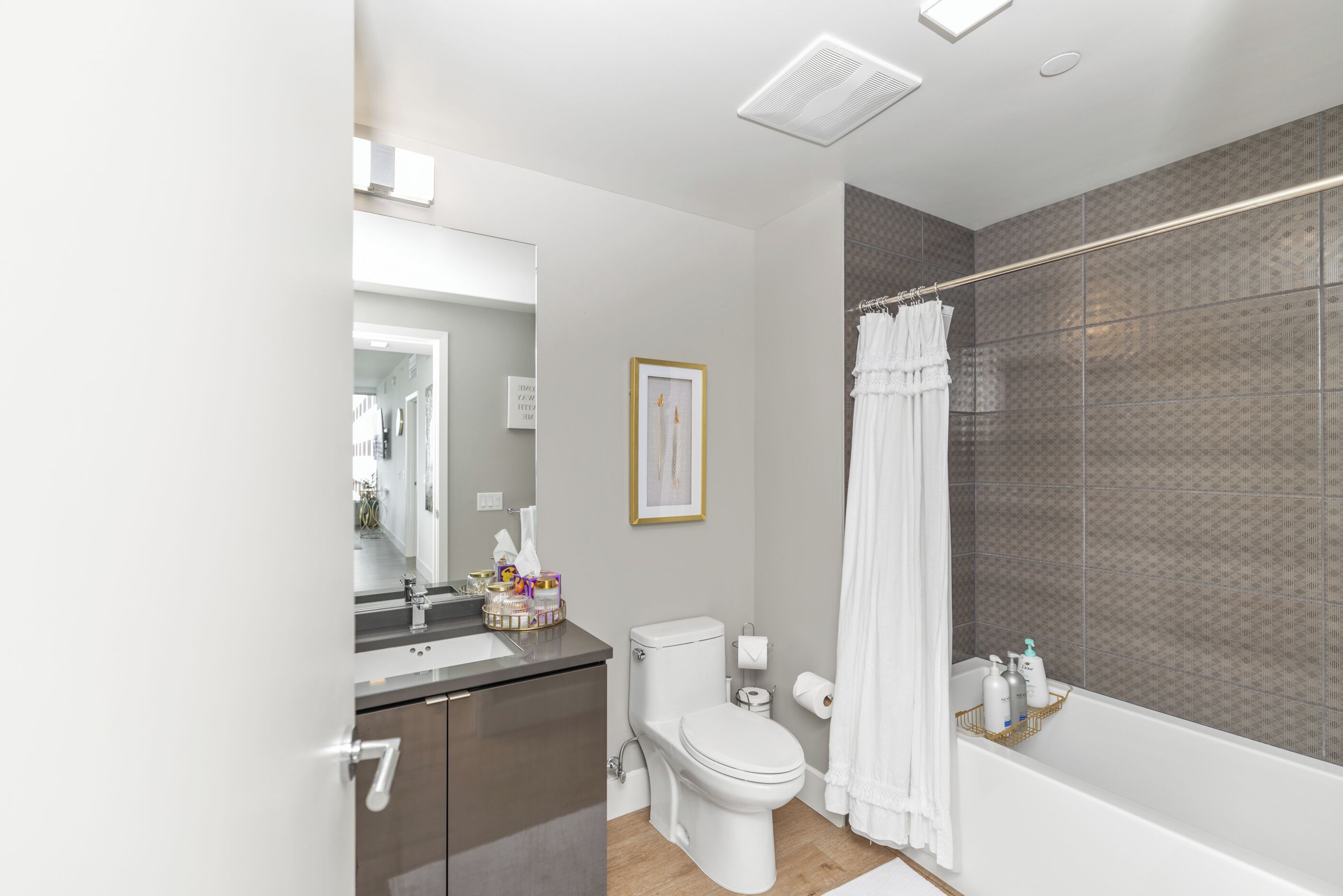 A modern bathroom with a toilet, sink, and shower area.