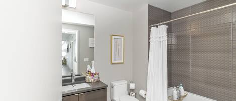 A modern bathroom with a toilet, sink, and shower area.