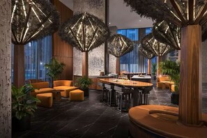 Een modern interieur met een bar, zitplaatsen en grote ramen.