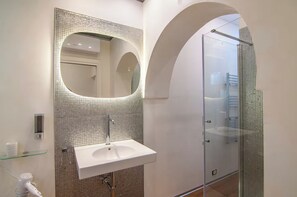 A modern bathroom with a glass shower enclosure, a white sink, and a tiled backsplash. - [Desiderium Home] A stone's throw from the Arena, Juliet's House, Roman Theater (Verona)