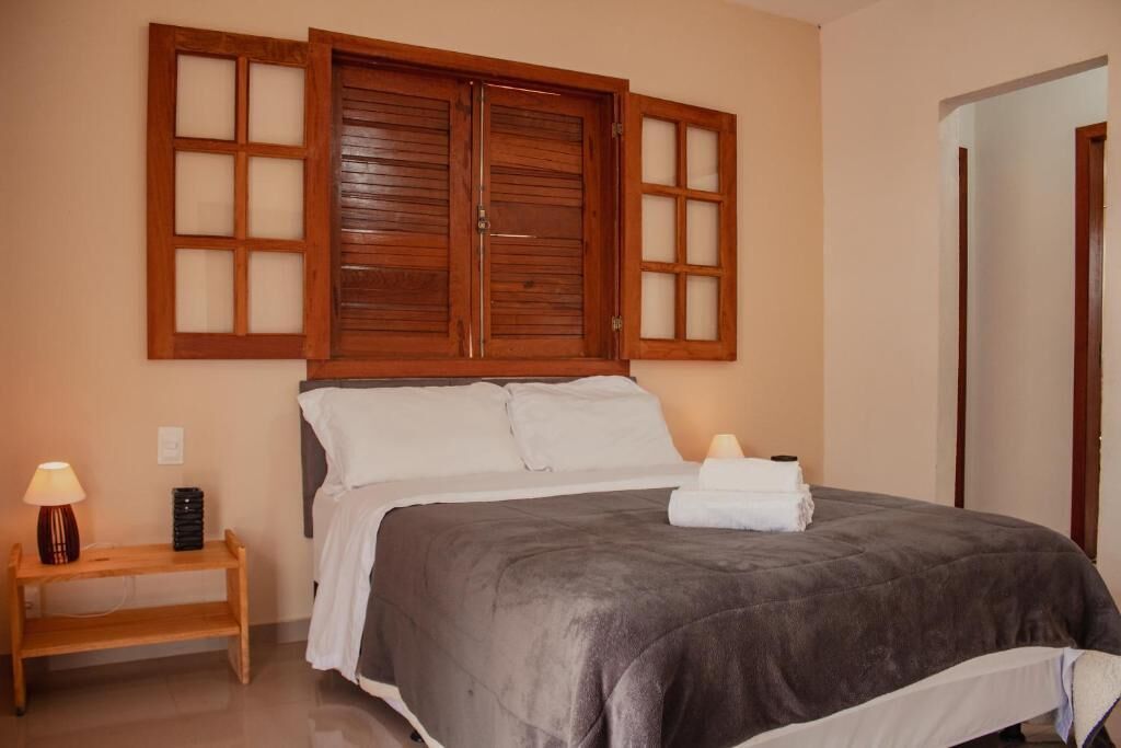 Une chambre à coucher avec un grand lit, une tête de lit en bois, des lampes de chevet et une table de chevet.