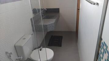 A small bathroom with a toilet, a shower, and a sink.
