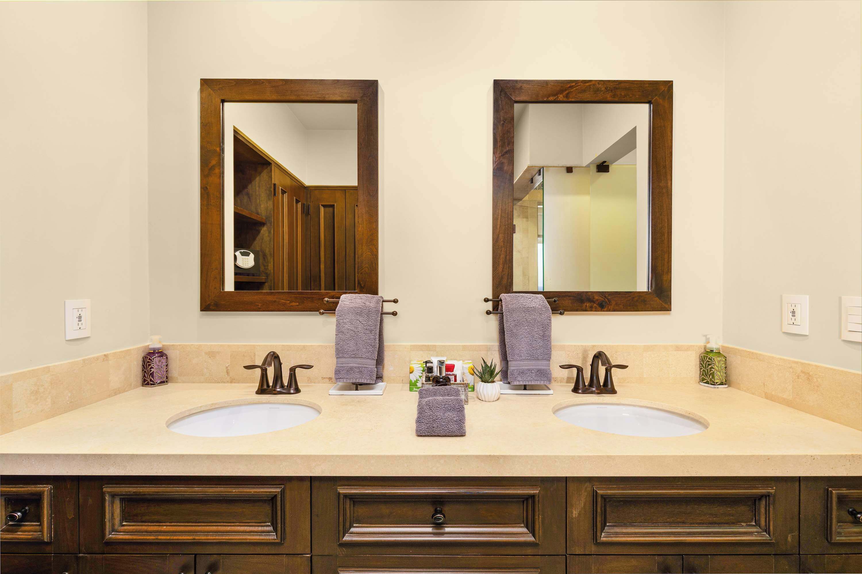 A bathroom with two sinks, wooden cabinets, and a mirror.