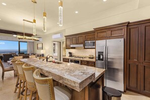 A modern kitchen with a large island, stainless steel appliances, and wooden cabinetry. - Ocean View Copala Condo | 3BR | Huge Balcony, Grill & Firepit (Cabo San Lucas)