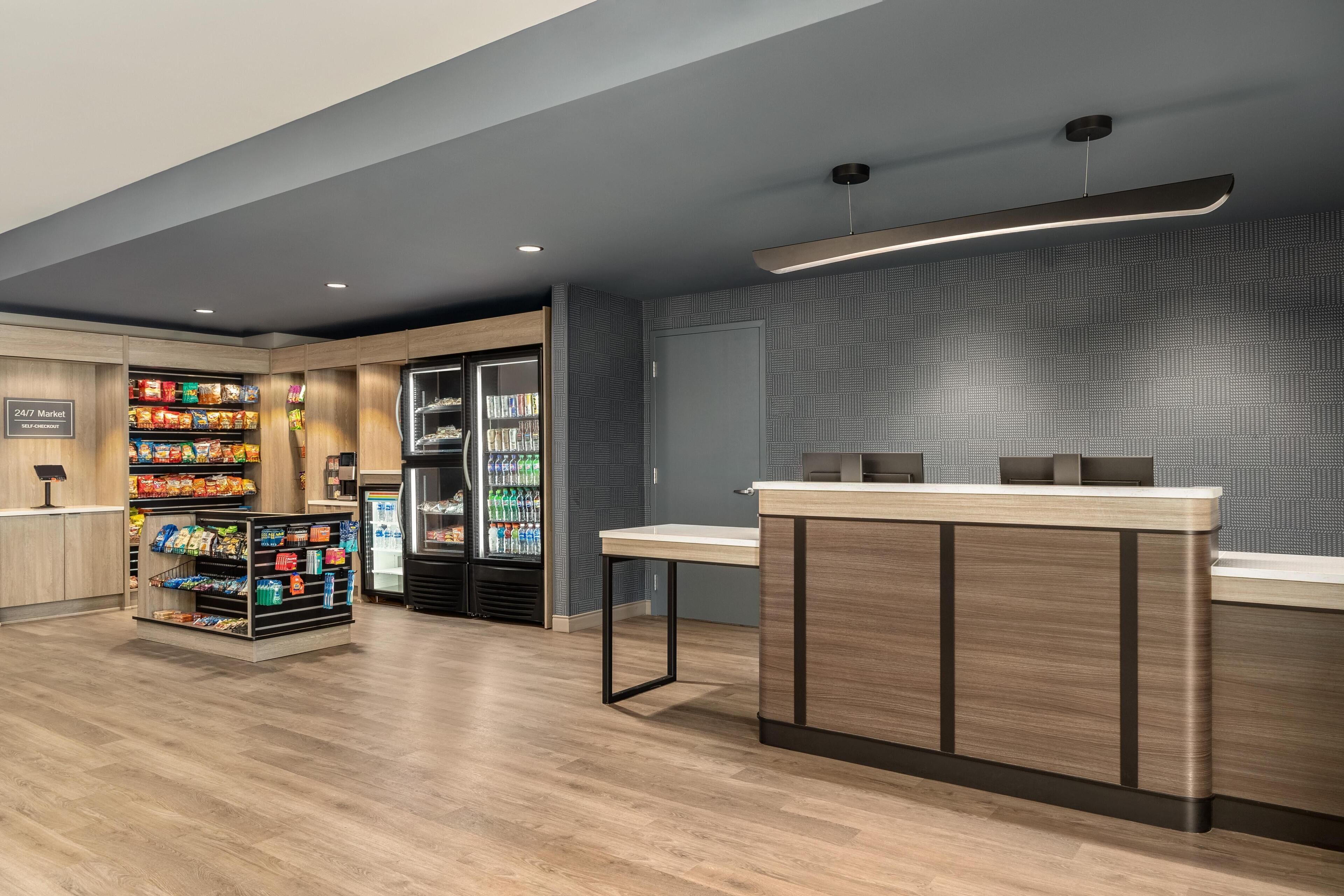 Un’area di self-checkout con un bancone in legno e una vetrina refrigerata.