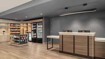 Un’area di self-checkout con un bancone in legno e una vetrina refrigerata.