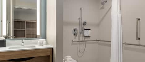 A modern bathroom with a shower, a sink, and a mirror.