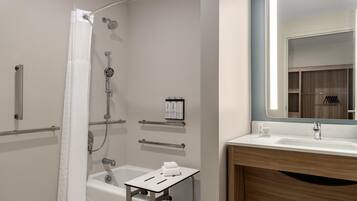 Un baño moderno con bañera, ducha y tocador con espejo.