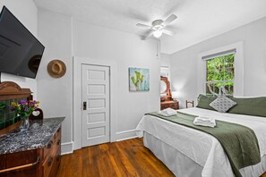 A bedroom with a bed, a television, a ceiling fan, a window, and a door. - Walk to Brevard | Fenced Yard + Relaxing Porch (Brevard)