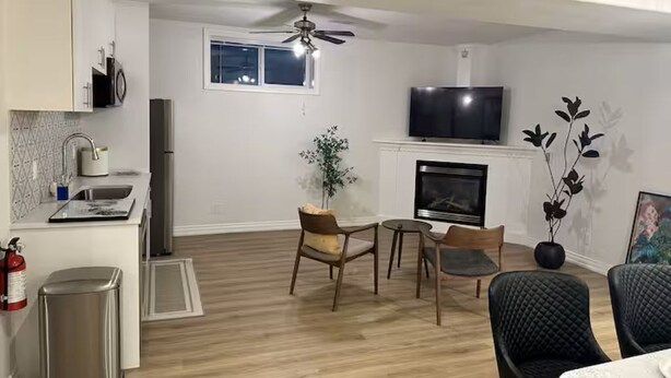 Ein modernes Wohnzimmer mit Kamin, Fernseher und Essbereich.