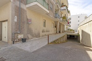 A narrow alleyway between buildings with a metal railing, a trash bin, and a utility box. - This colorful and welcoming apartment, ideal for up to 4 people, is strategically located in Lecce: outside the restricted traffic zone but just steps from the historic center. Just 400 meters from Porta San Biagio, it's easy to immerse yourself in the w (Otranto)
