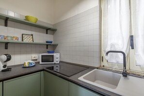 Eine Küche mit Mikrowelle, Wasserkocher und Spüle.