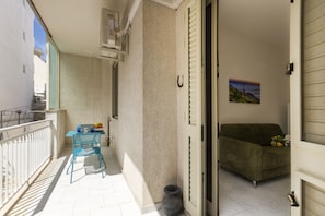 A balcony with a table, chairs, and a potted plant. - This colorful and welcoming apartment, ideal for up to 4 people, is strategically located in Lecce: outside the restricted traffic zone but just steps from the historic center. Just 400 meters from Porta San Biagio, it's easy to immerse yourself in the w (Otranto)