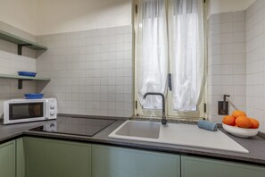 A kitchen with a microwave, sink, and a bowl of oranges. - This colorful and welcoming apartment, ideal for up to 4 people, is strategically located in Lecce: outside the restricted traffic zone but just steps from the historic center. Just 400 meters from Porta San Biagio, it's easy to immerse yourself in the w (Otranto)