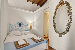 Une chambre à coucher avec un lit, un miroir fixé au mur et une lampe de chevet.