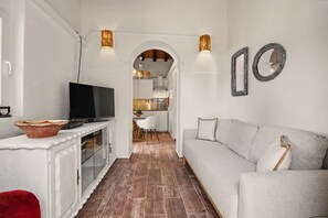 Un salon moderne avec un téléviseur, un canapé et des miroirs décoratifs.