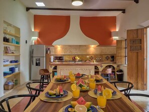 Ein Essbereich mit einem Holztisch, gedeckt für eine Mahlzeit, umgeben von Stühlen.
