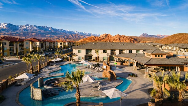Ein Resort mit Swimmingpool, Palmen und Bergblick.