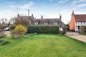 A traditional house with a thatched roof, a well-maintained lawn, and a hedge in front. - Lavender Cottage Cosy Country Escape - Pure Nature- Train London 30 min. (Aldbury)