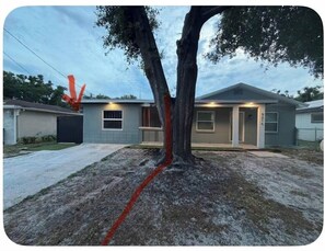 A residential property with a house, a driveway, and a tree. - Chic Private Suite for 6 near USF & Busch Garden (Tampa)