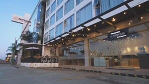 A hotel with a reception area, a sign for 'Alambique Hotel Express,' and a covered outdoor seating area.
