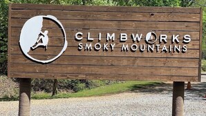 A wooden sign with the text 'CLIMBWORKS SMOKY MOUNTAINS' and a climbing icon.