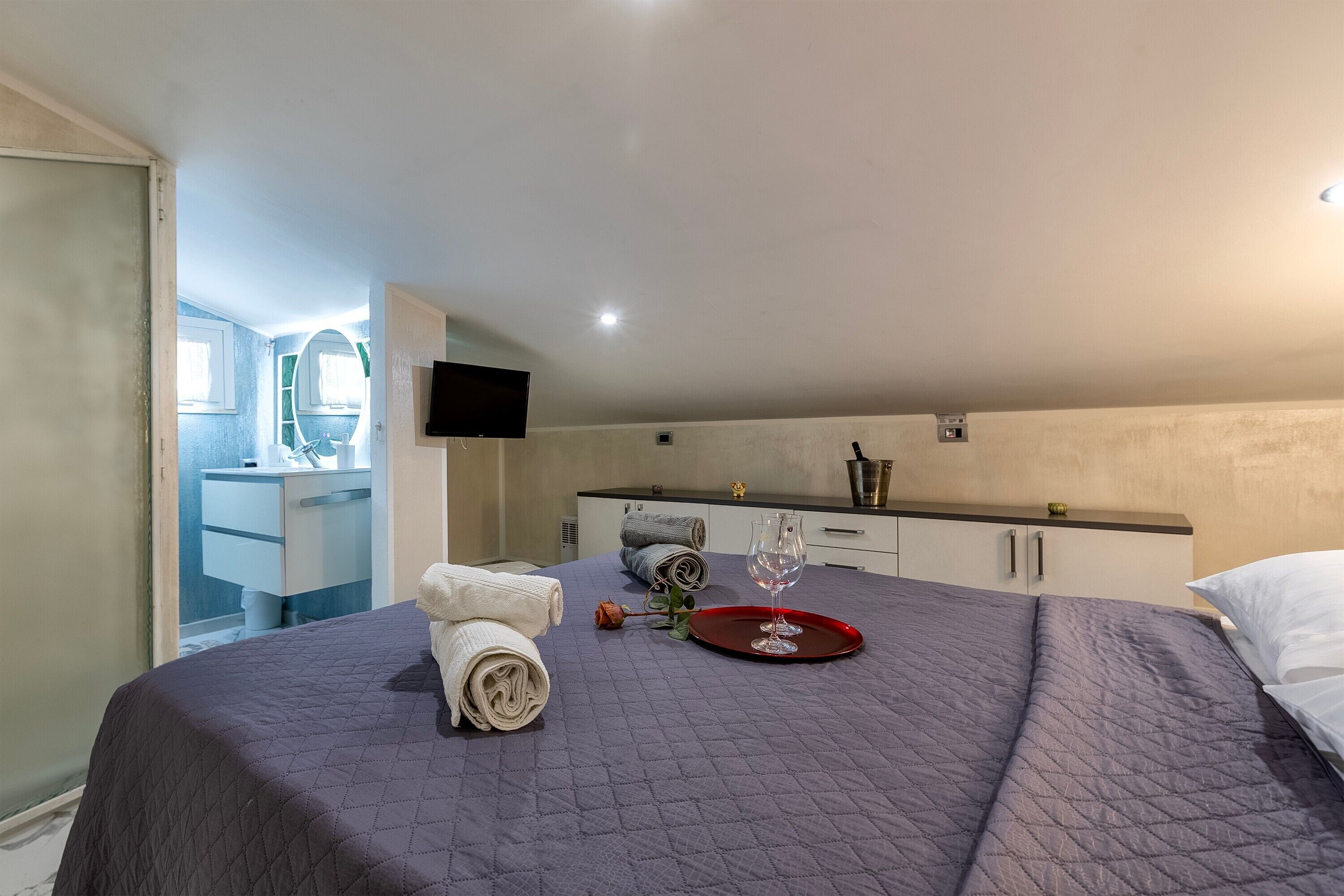 Ein Hotelzimmer mit Bett, Fernseher, Küchenzeile und Badezimmer.