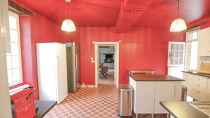 A kitchen with red walls, a checkered floor, and two pendant lights. - So Villa La Messagerie (49) - Heated pool - Basketball - 2 hours from Nantes - Sleeps 36. (Noyant)