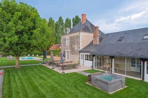 A two-story house with a swimming pool, outdoor seating, and a hot tub. - Villa La Messagerie (49) — Heated pool — Basketball — 2 hours from Nantes — Sleeps 36. (Noyant)